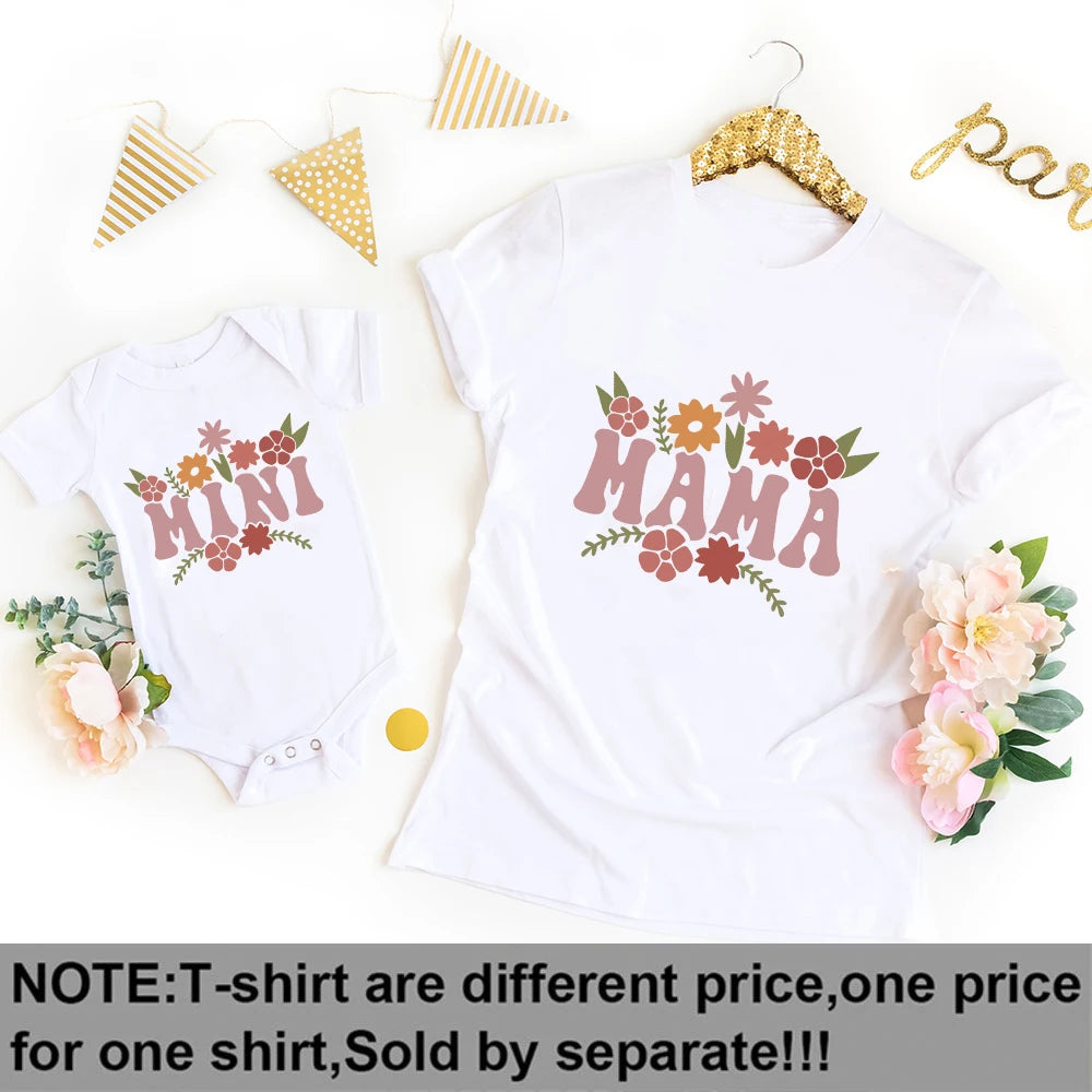 White short-sleeve "MAMA" t-shirt and "MINI" baby bodysuit with floral designs.
