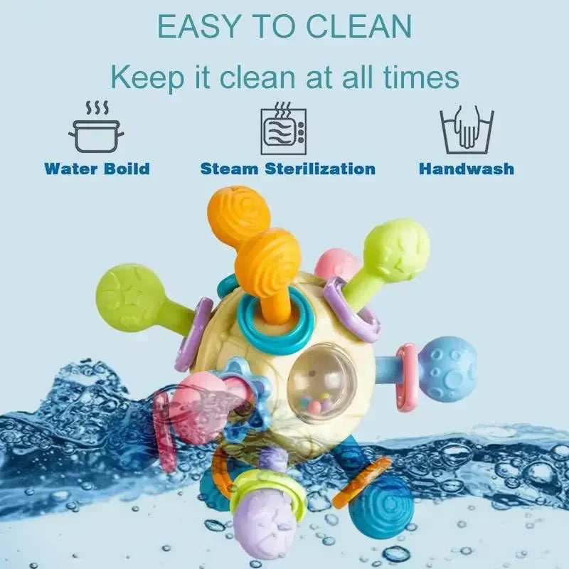 Colorful silicone spinning rattle ball for babies, with textured arms and internal beads, shown with cleaning icons.