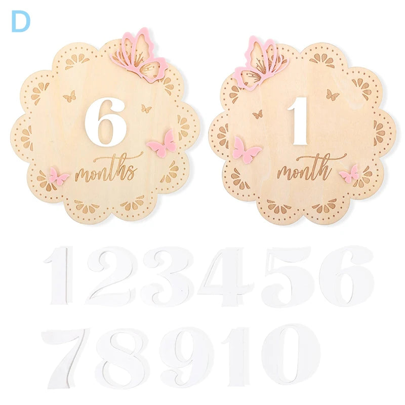 Wooden baby milestone cards with pink butterflies, numbers 1-10, and "month/months" text.
