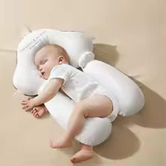 Sleeping baby on a white ergonomic newborn pillow with head and body support.