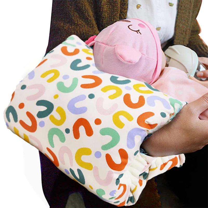 White cotton nursing pillow with colorful abstract arch pattern, supporting a baby doll.