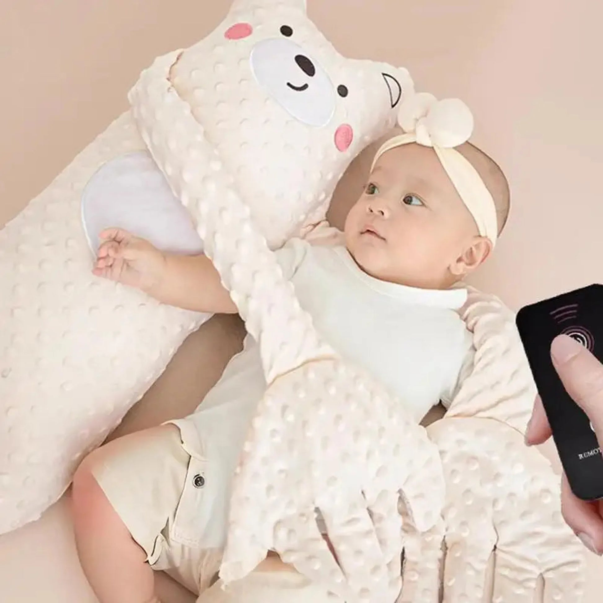 Baby in a white bear-shaped electric soothing pillow with remote control.