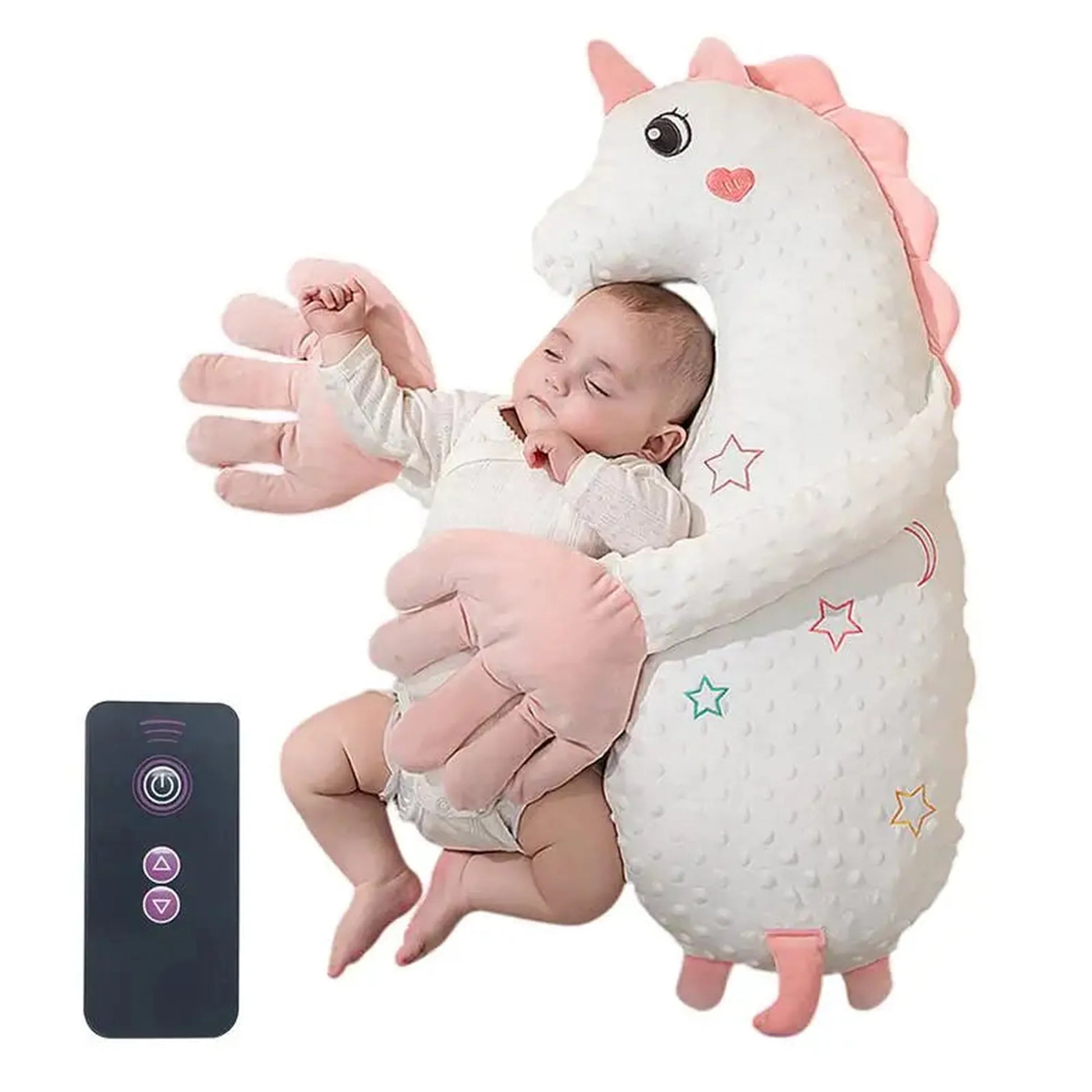 Baby sleeping soundly in a white unicorn electric soothing pillow with pink hands, beside a black remote.