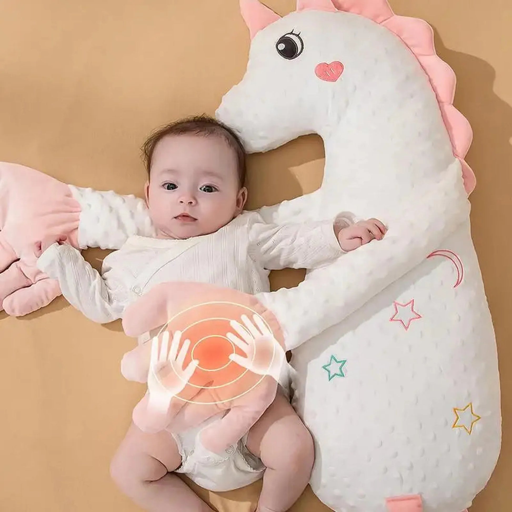 Baby with a white unicorn electric soothing pillow, featuring pink accents and a gentle tapping mechanism.