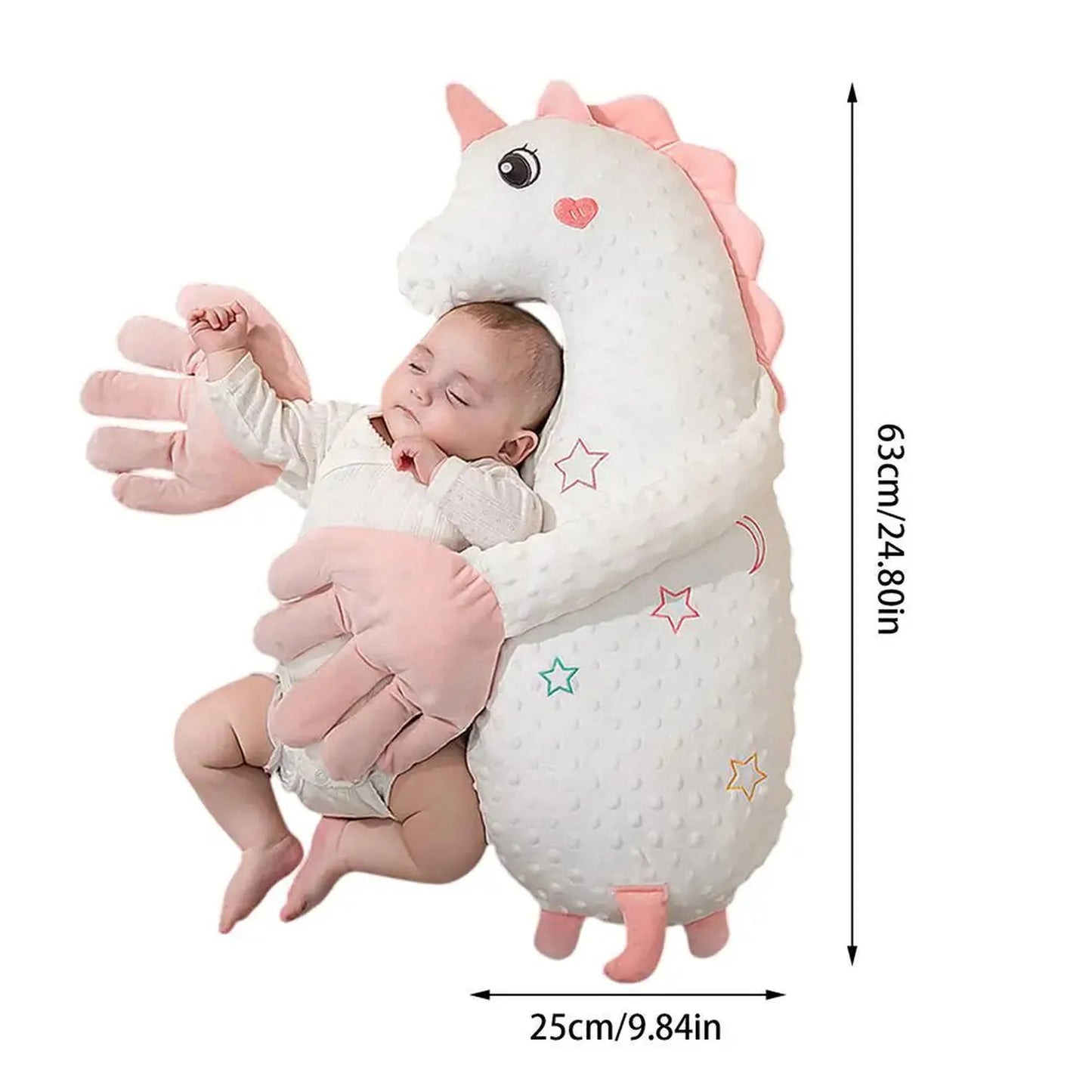 Baby sleeping soundly, hugged by a white unicorn electric soothing pillow with pink hands, 63x25cm.
