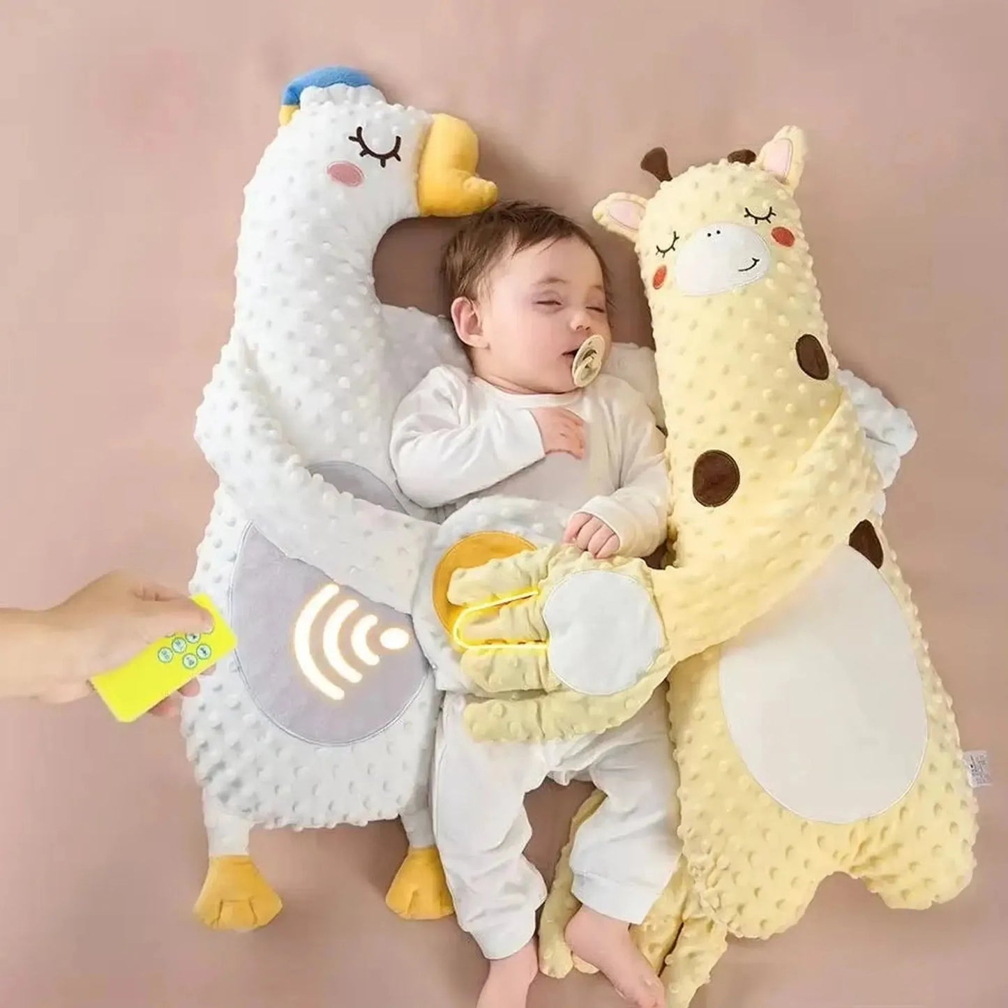 Baby sleeping peacefully between a white duck and yellow giraffe electric soothing pillows, controlled by a remote.