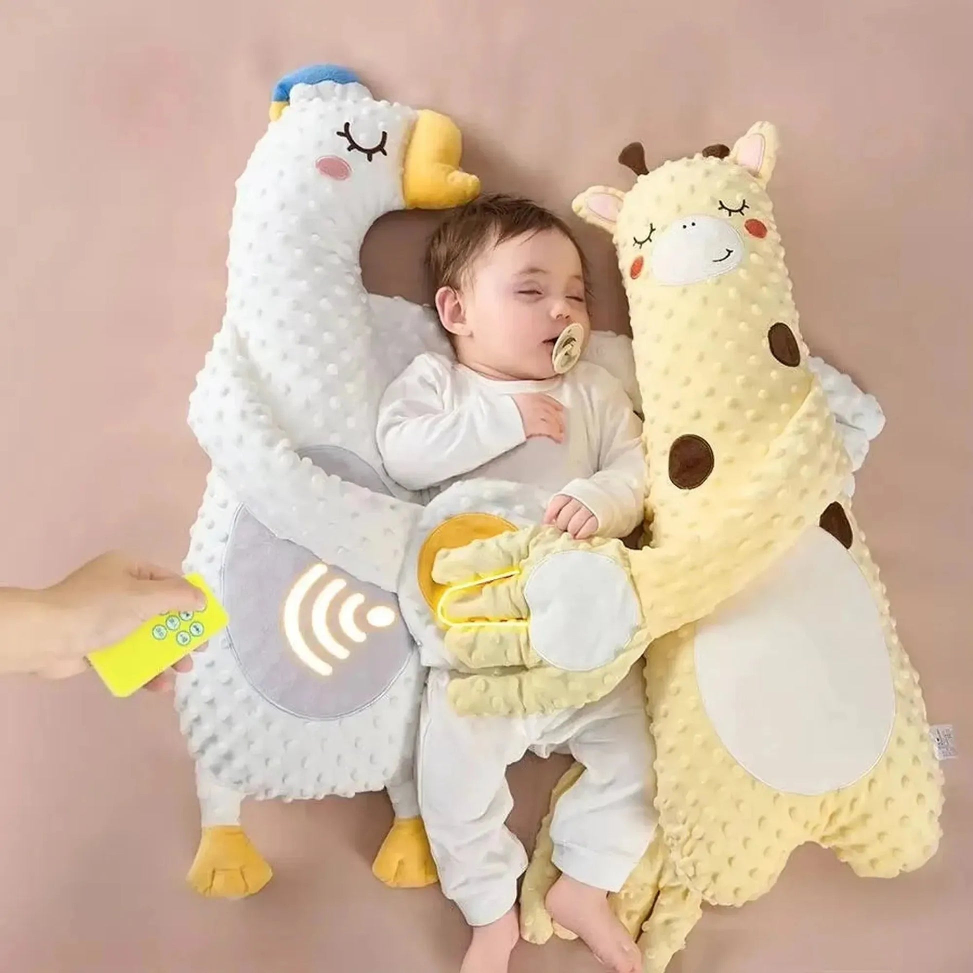Baby sleeping peacefully between a white duck and yellow giraffe electric soothing pillows, controlled by a remote.