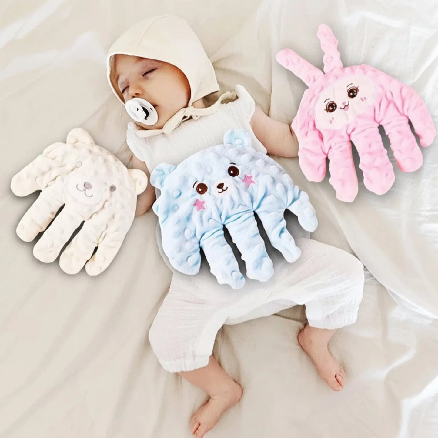 Sleeping baby with pacifier, surrounded by three soft, hand-shaped calming pillows: white bear, blue bear, and pink bunny.
