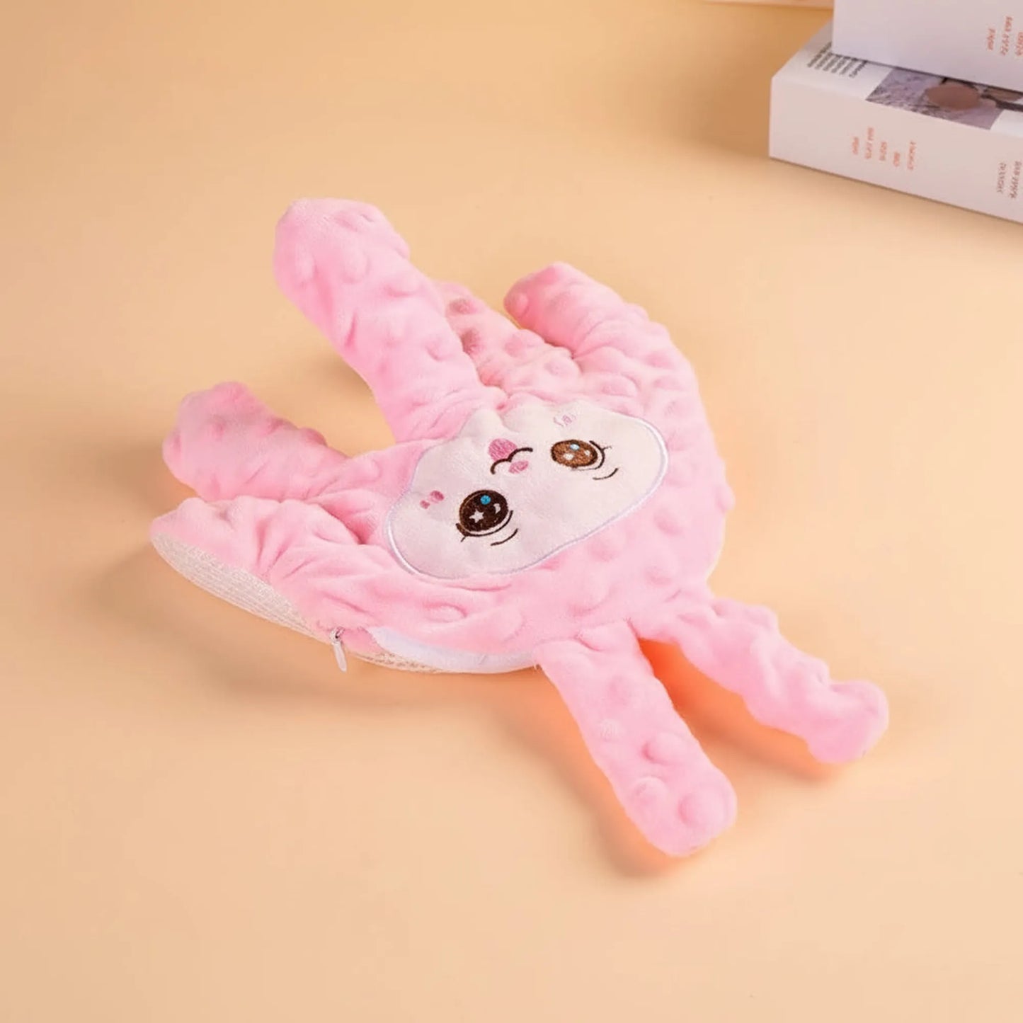 Pink plush baby soothing pillow shaped like a hand with a cute bunny face and textured fabric.