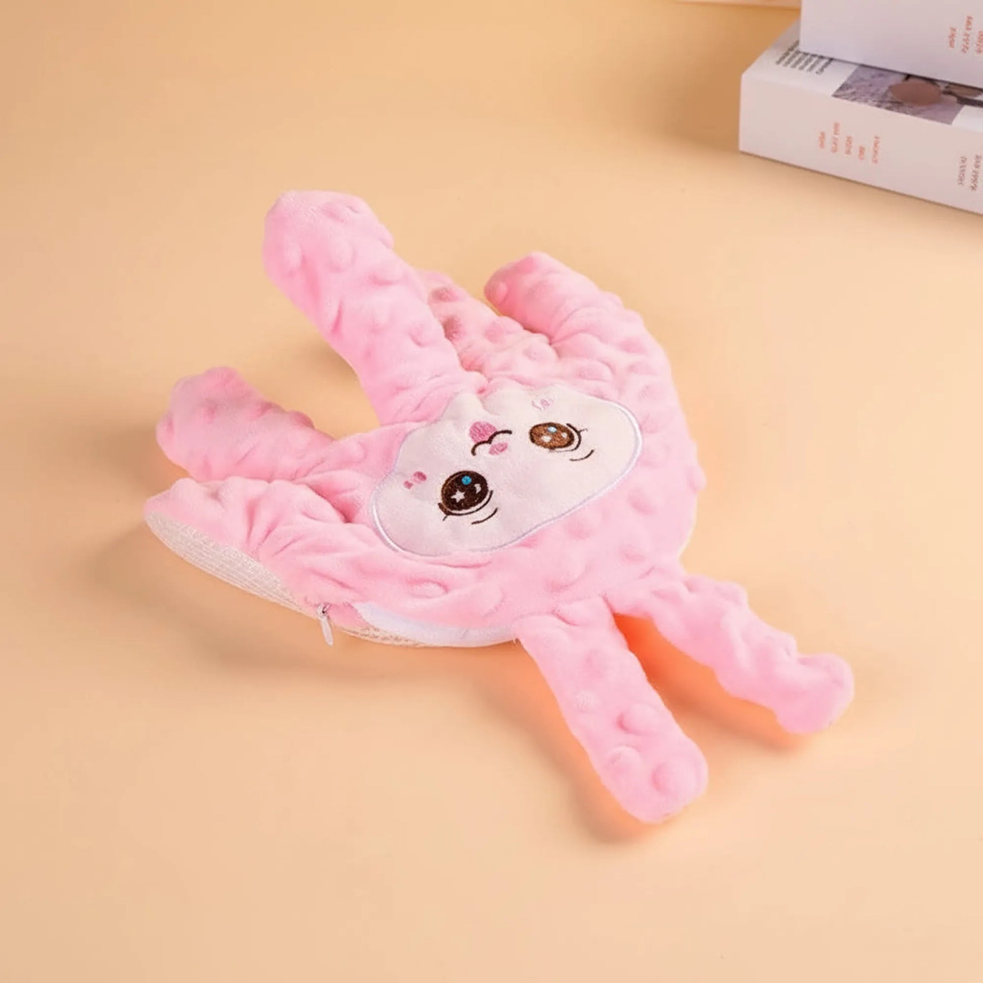 Pink plush baby soothing pillow shaped like a hand with a cute bunny face and textured fabric.