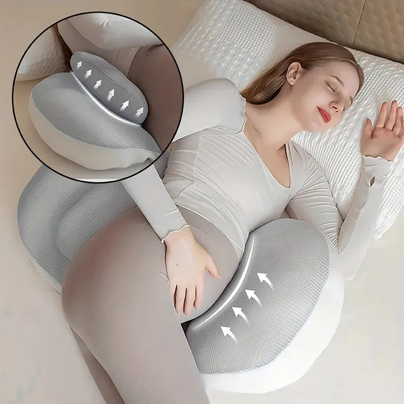 Pregnant woman sleeping peacefully with a gray and white U-shaped pregnancy pillow, supporting her back and belly.
