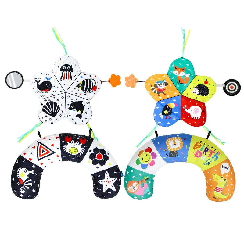Two baby tummy time pillows, one in high-contrast black and white with sea creatures, the other colorful with animals and "Happy Birthday.