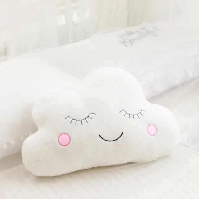 Soft white cloud-shaped plush pillow with embroidered sleeping eyes and pink rosy cheeks for baby decor.