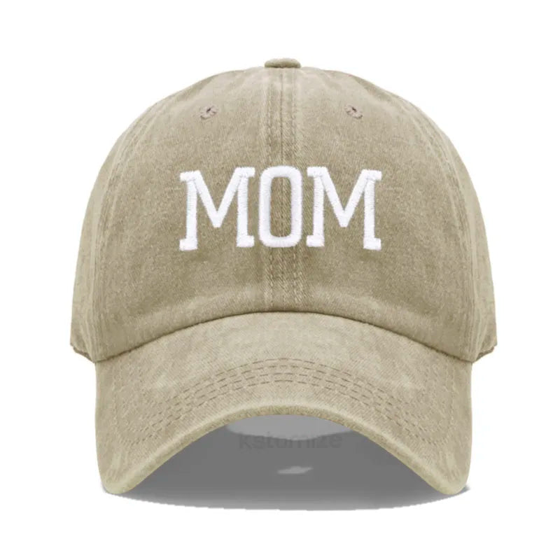 Adjustable beige cotton baseball cap with "MOM" embroidered in white.