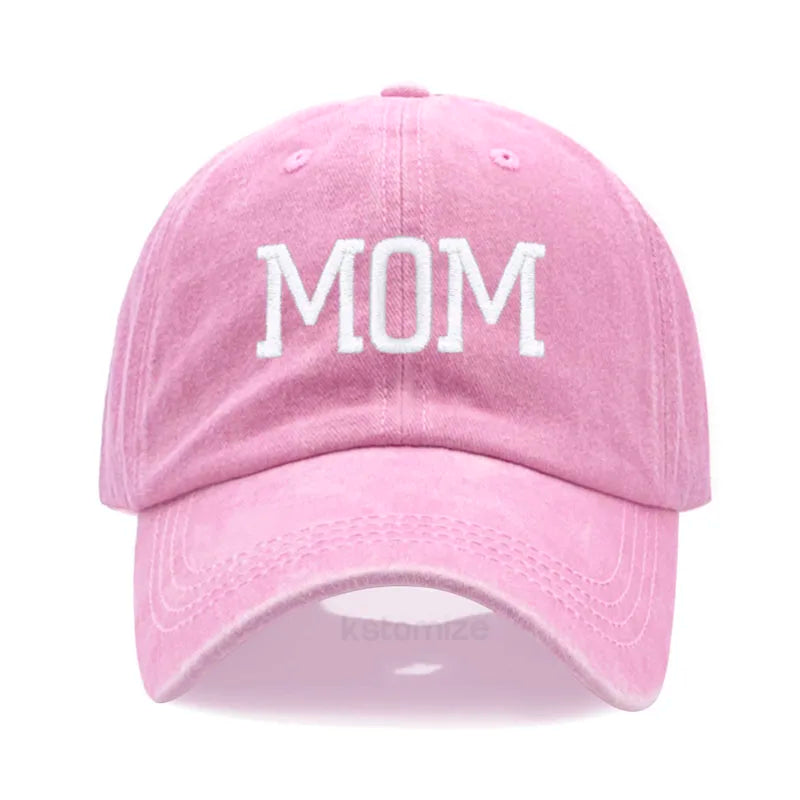 Pink cotton baseball cap with "MOM" embroidered in white, adjustable and unisex.