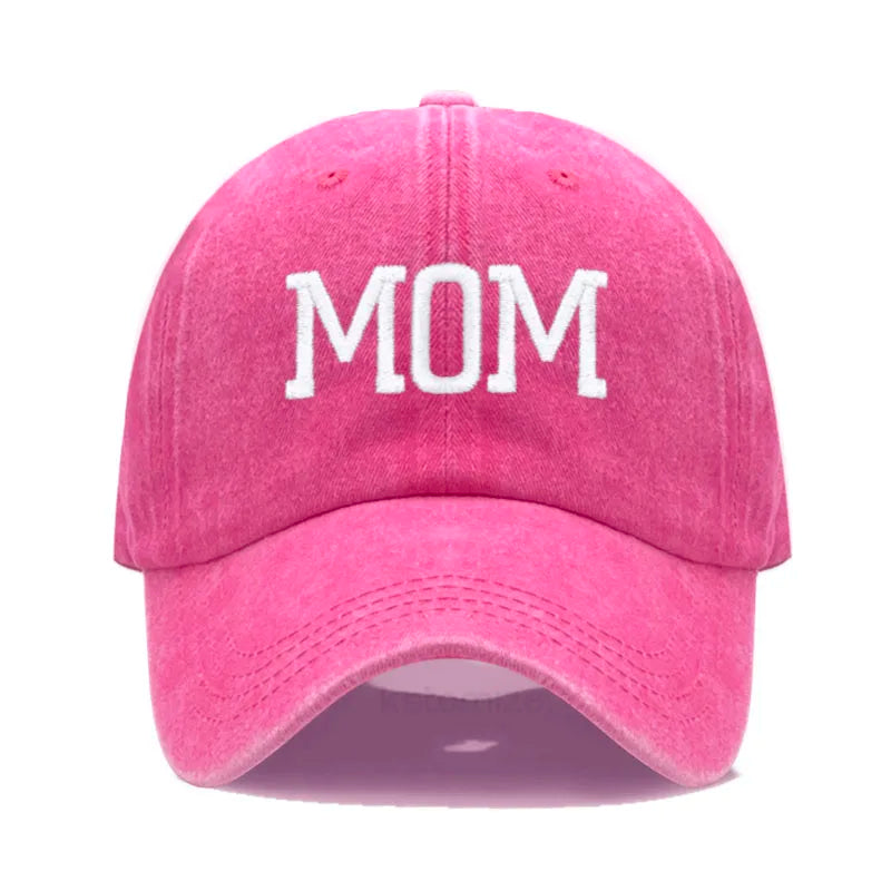 Pink washed cotton baseball cap with "MOM" embroidered in white, adjustable unisex design.