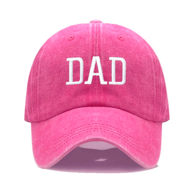 Pink cotton baseball cap with "DAD" embroidered in white, adjustable for comfort.