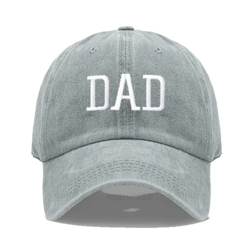 Adjustable light gray cotton baseball cap with "DAD" embroidered in white.