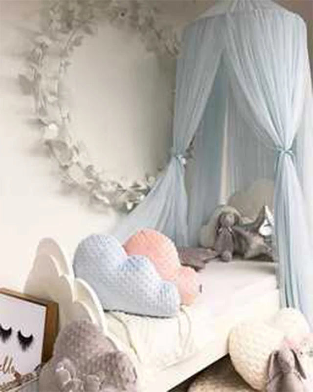 Light blue sheer canopy with star decorations over a white crib, featuring heart pillows.