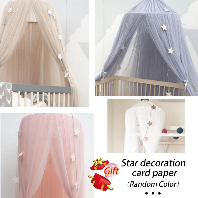 Baby crib canopy in beige, blue, and pink tulle with hanging star decorations.