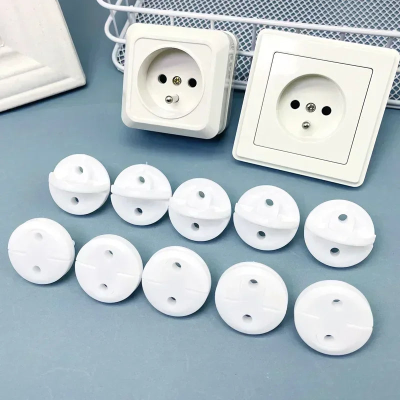 White ABS plastic child safety outlet covers for French standard sockets, shown with two wall outlets.