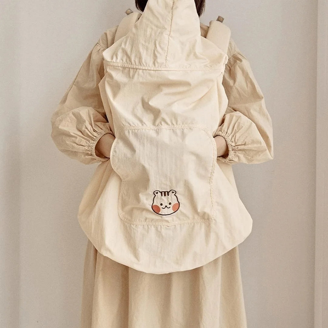 Beige polyester baby carrier and stroller cover with a cute bear face embroidery and hood.