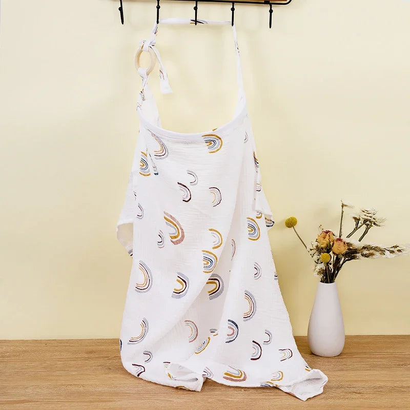 White cotton nursing cover with colorful rainbow print and adjustable strap.
