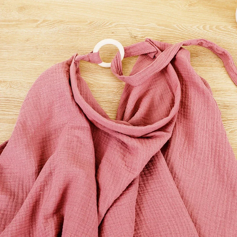 Pink cotton nursing cover and stroller blanket with adjustable white ring.