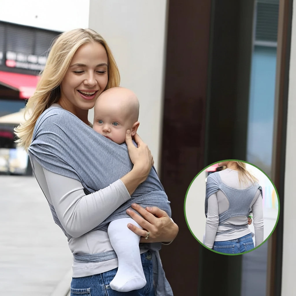 Smiling mom holds baby in a soft gray ergonomic cotton baby wrap carrier, showing back support.