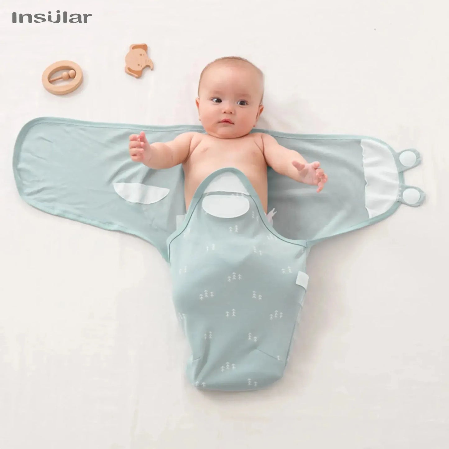Baby swaddle in light blue with white tree pattern, open with infant inside, 100% cotton.