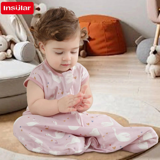 Baby in a pink cotton sleeping bag with white swan print and two-way zipper, sitting on a rug.