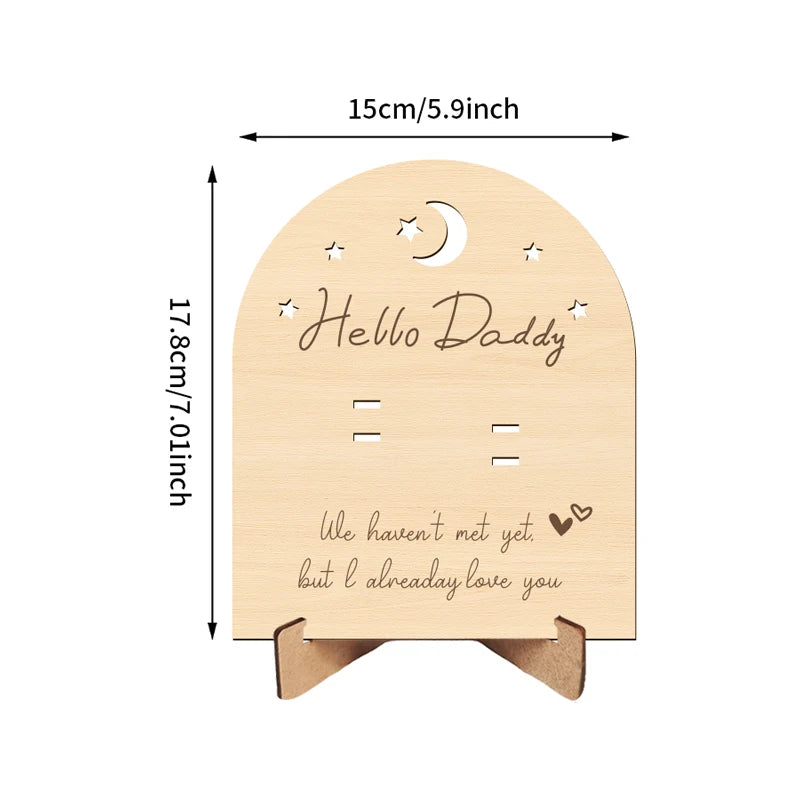 Wooden pregnancy announcement sign with "Hello Daddy" and "We haven't met yet but I already love you" text.