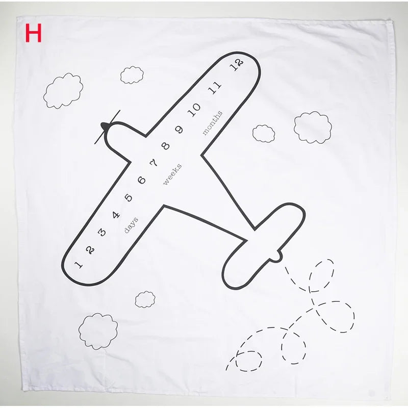 White polyester baby milestone blanket with black airplane and cloud design, marked for tracking growth.