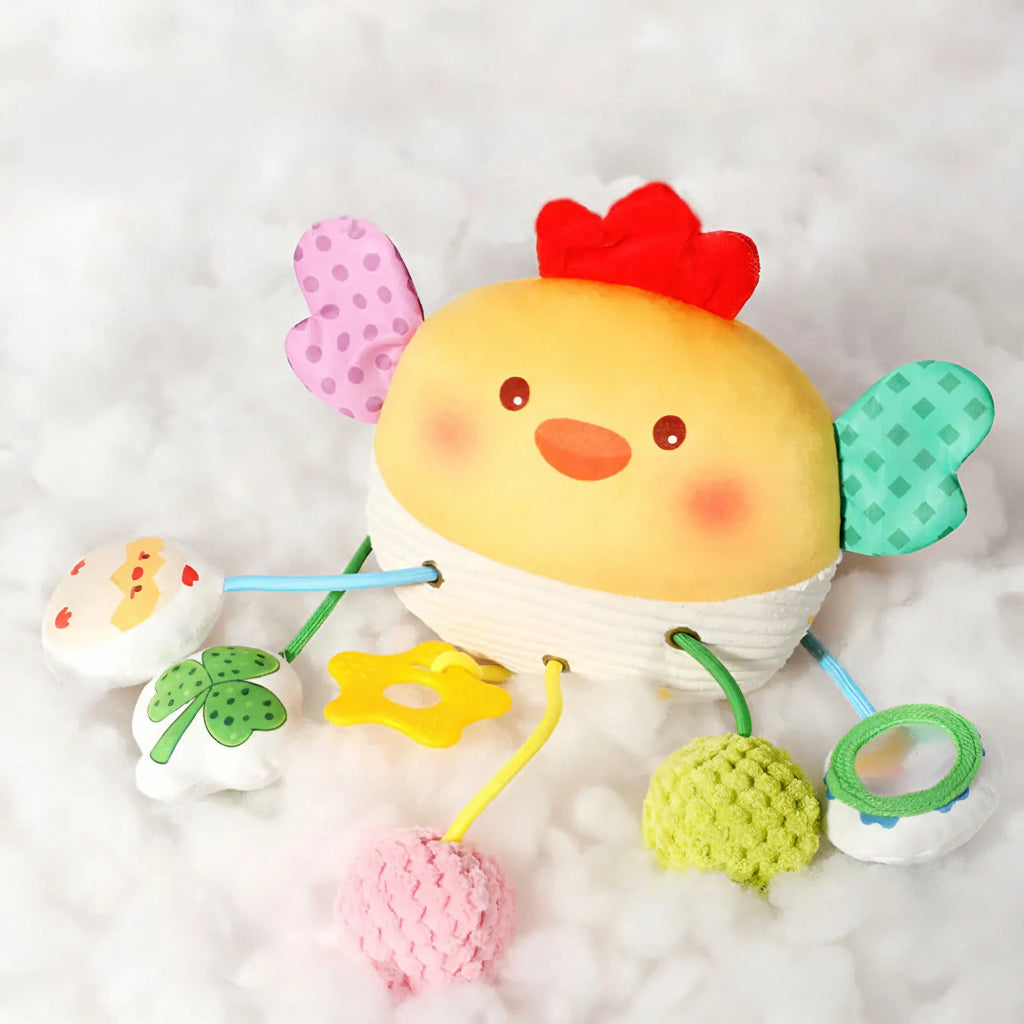 Soft yellow chicken crib toy with colorful wings, pull mechanism, and dangling rattles.