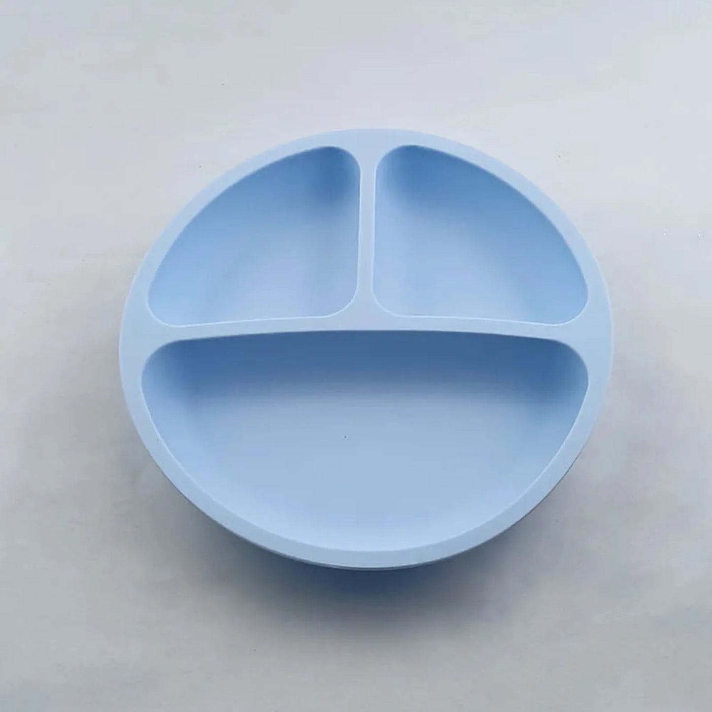 Light blue silicone baby plate with three divided sections and a strong suction base.