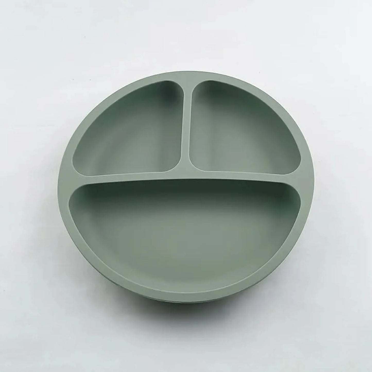 Green silicone suction plate for self-feeding, with three divided sections for toddlers.