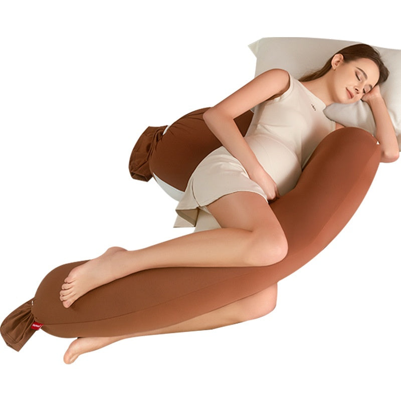 Pregnant woman sleeping peacefully on a brown U-shaped full body pregnancy pillow.