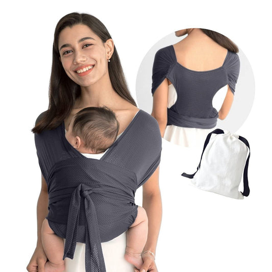 Smiling mom carrying baby in a dark gray breathable mesh X-Type ergonomic baby carrier, with a white storage bag.