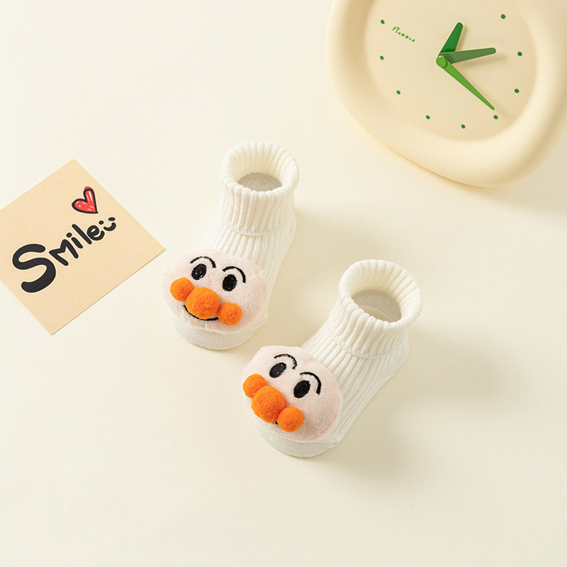 White cotton baby socks with cute cartoon faces and anti-slip soles.