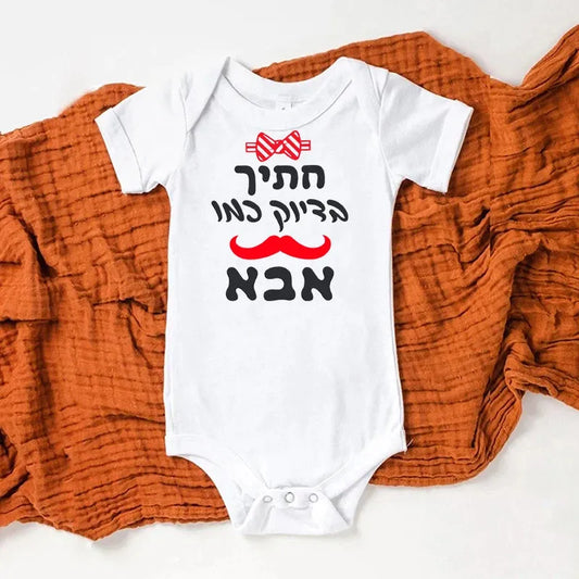 White short-sleeve baby bodysuit with "Handsome like Dad" text, red bow tie, and mustache graphic.