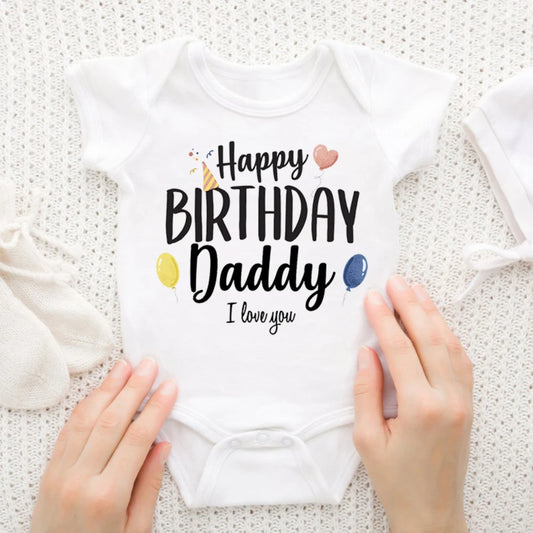 White baby bodysuit with "Happy Birthday Daddy I love you" text, party hat, heart, and balloons.
