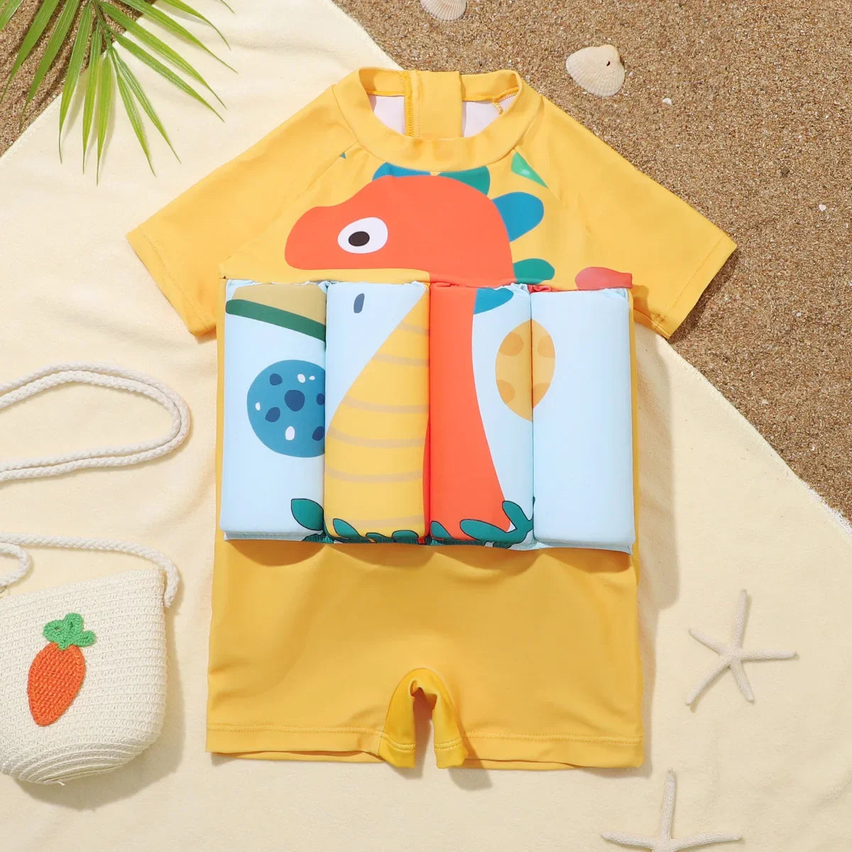 Yellow kids' floatation swimsuit with a colorful cartoon dinosaur print and built-in swim aids.