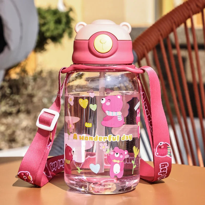 Pink 650ml kids' water bottle with bear design, straw, handle, and carrying strap.