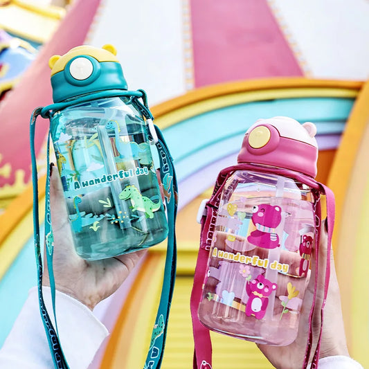 Two kids' water bottles with straws and handles: one teal with dinosaurs, one pink with bears.