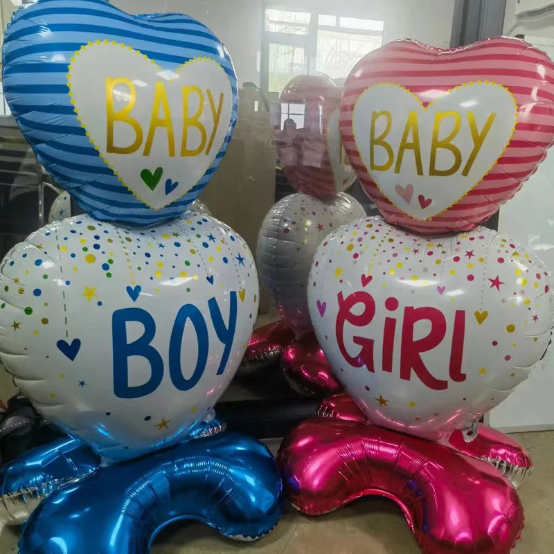 Heart-shaped foil balloons for gender reveal: blue "BABY BOY" and pink "BABY GIRL" designs.