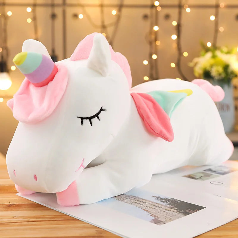 Soft white plush unicorn toy with pink mane, rainbow horn, and pastel wings.
