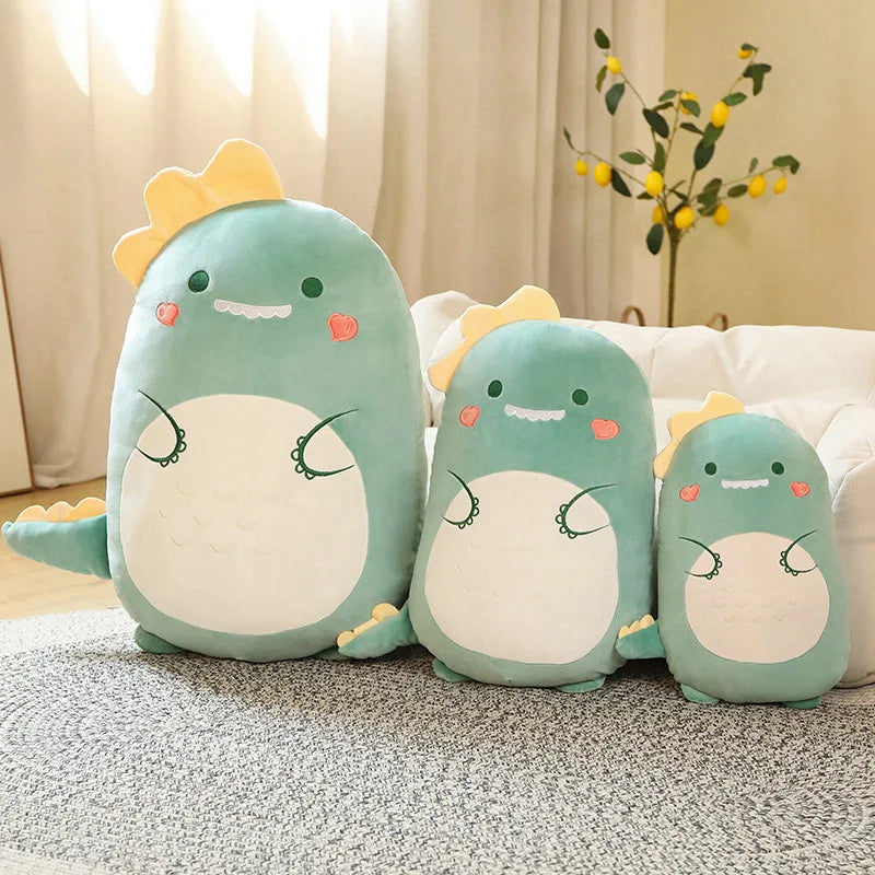Three soft plush green dinosaur pillow toys in varying sizes (45-80cm) on a rug.