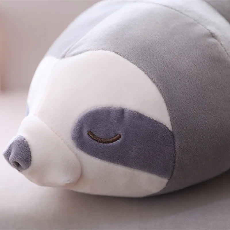 Soft gray and white plush sloth toy with embroidered closed eyes and a small nose.