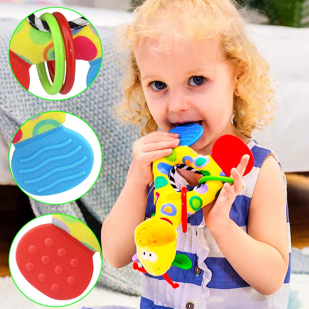 Toddler holding a yellow giraffe plush rattle and teether with colorful rings and textured silicone.