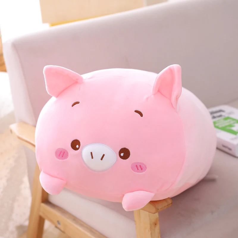 Soft pink plush pig animal pillow, 20cm, with embroidered features, resting on a chair.